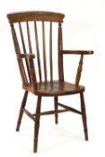 A 19th century stick back elbow chair with elm solid seat on turned legs,