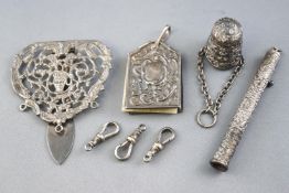 A silver chatelaine clip, decorated with C and S scrolls and a mask with loops for three chains,