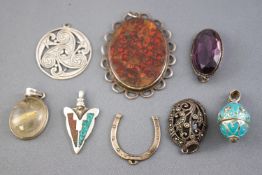 A collection of eight silver pendants of variable designs.