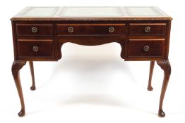 A mahogany writing table with three inset leather skivers over one long and four short drawers