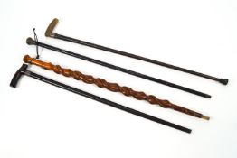 Three ebonised walking canes, one silver topped, two with silver collars,