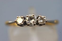 A yellow and white metal three stone diamond ring,