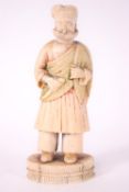 An early 20th century Indian carved ivory figure with the remains of red and green staining