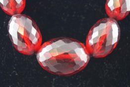 A single strand of red faceted graduated beads,