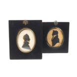 Two highlighted silhouettes of gentlemen in Regency costume in oval brass surrounds