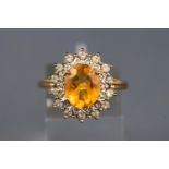 A yellow and white metal cluster ring, set with an oval faceted cut citrine,