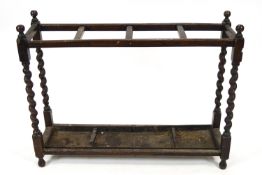 An oak stick stand, the top with four sections on barley twist supports, 70.