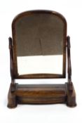 A Victorian mahogany swing mirror with arched top and compartment,