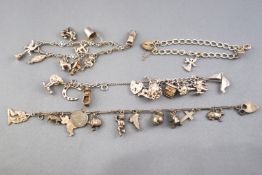 A collection of four silver charm bracelets , each fitted with various charms.