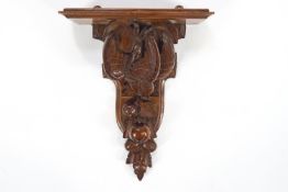 A carved oak wall bracket, with dead game above fruiting branch,