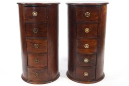 A pair of hardwood cylinder chests of five drawers, with ring handles,