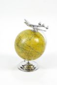 An Art Deco style globe on chrome plated stand, surmounted by a four-prop plane,