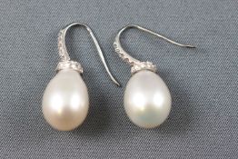 A white metal pair of drop earrings,