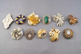 A collection of twenty costume brooches of variable designs.