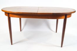 A G plan teak D end extending dining table with fold out central leaf over a plain frieze