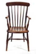 A 19th century stick back elbow chair with solid elm seat on turned legs linked by H stretchers,
