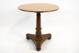 An oak circular occasional table on a triform base,