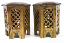 A pair of Moroccan style stools with leather seats supported by a gold painted frame,