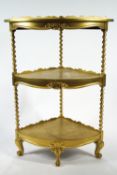 A Victorian style gold effect three-shelf whatnot of usual corner form,