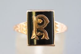 A yellow metal Masonic signet ring set with black onyx and embellished with an R initial,