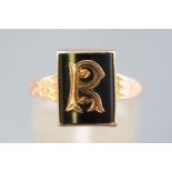 A yellow metal Masonic signet ring set with black onyx and embellished with an R initial,