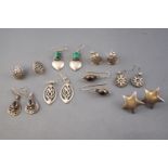 A collection of eight pairs of silver earrings of variable designs consisting of drops and studs.