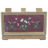 A framed beadwork picture of insects, white flowers and foliage on a red ground,