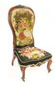 A 19th century nursing chair, upholstered with embroidered floral designs,