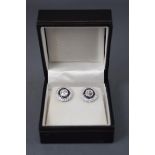 A white metal pair of cluster stud earrings,