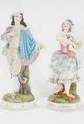 A matched pair of French bisque figurines in 18th century dress, 42cm high,