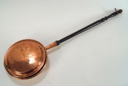 A 19th century copper warming pan with ebonised turned wood handle,