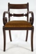 A Regency mahogany Revival style elbow chair with plain curved rectangular back