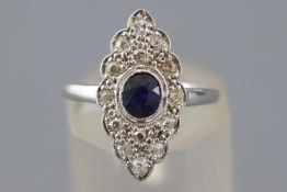 A white metal dress ring set with an oval faceted cut blue sapphire and old cut diamonds.