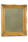 A shaped pine framed wall mirror,