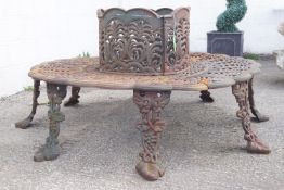 A four section circular garden tree seat, of cast metal with stylised flowers and acanthus design,