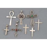 A collection of eight silver cross pendants of variable designs.