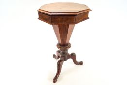 A Victorian mahogany sewing table of hexagonal form, tapering to emerge as three carved legs,