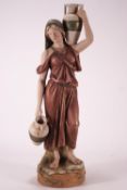 A Royal Dux figure of a lady water carrier, seen carrying two urns, pink applied pad,