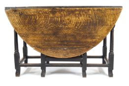 An 18th century provincial oak oval dropleaf table raised on turned stretchered legs