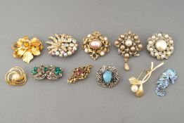 A collection of twenty costume brooches of variable designs.