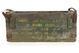 A painted wood military smoke bomb case with metal bandings,