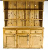 A Victorian style pine dresser, the canted top with cornice over two shelves,