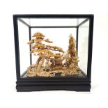 A cork Diorama model, hard wood cased and glazed, depicting a group of pagoda style buildings,