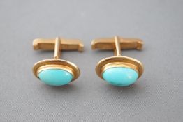 A yellow metal pair of cufflinks each set with and oval cabochon turquoise (stones untested).