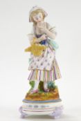 A French bisque figure of a lady holding a basket of eggs,
