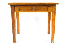 A pine table with one frieze drawer, fitted for cutlery on square tapering legs,