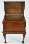 A hardwood two handled chest on stand with carved cabriole legs with ball and claw feet,