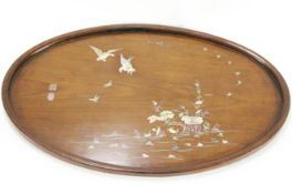 A Japanese oval hardwood tray, inlaid with mother of pearl with geese in flight above a river....