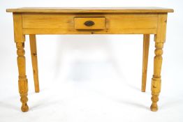 A pine side table with plain rectangular top over a plain frieze set a central small drawer