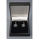 A yellow and white metal pair of flower drop earrings,